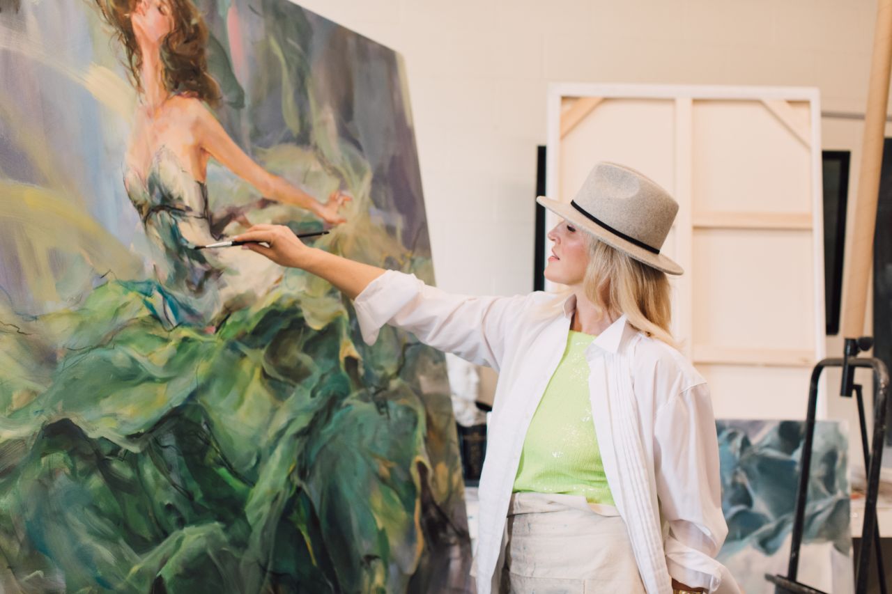Anna Razumovskaya adding brushwork to a large green canvas