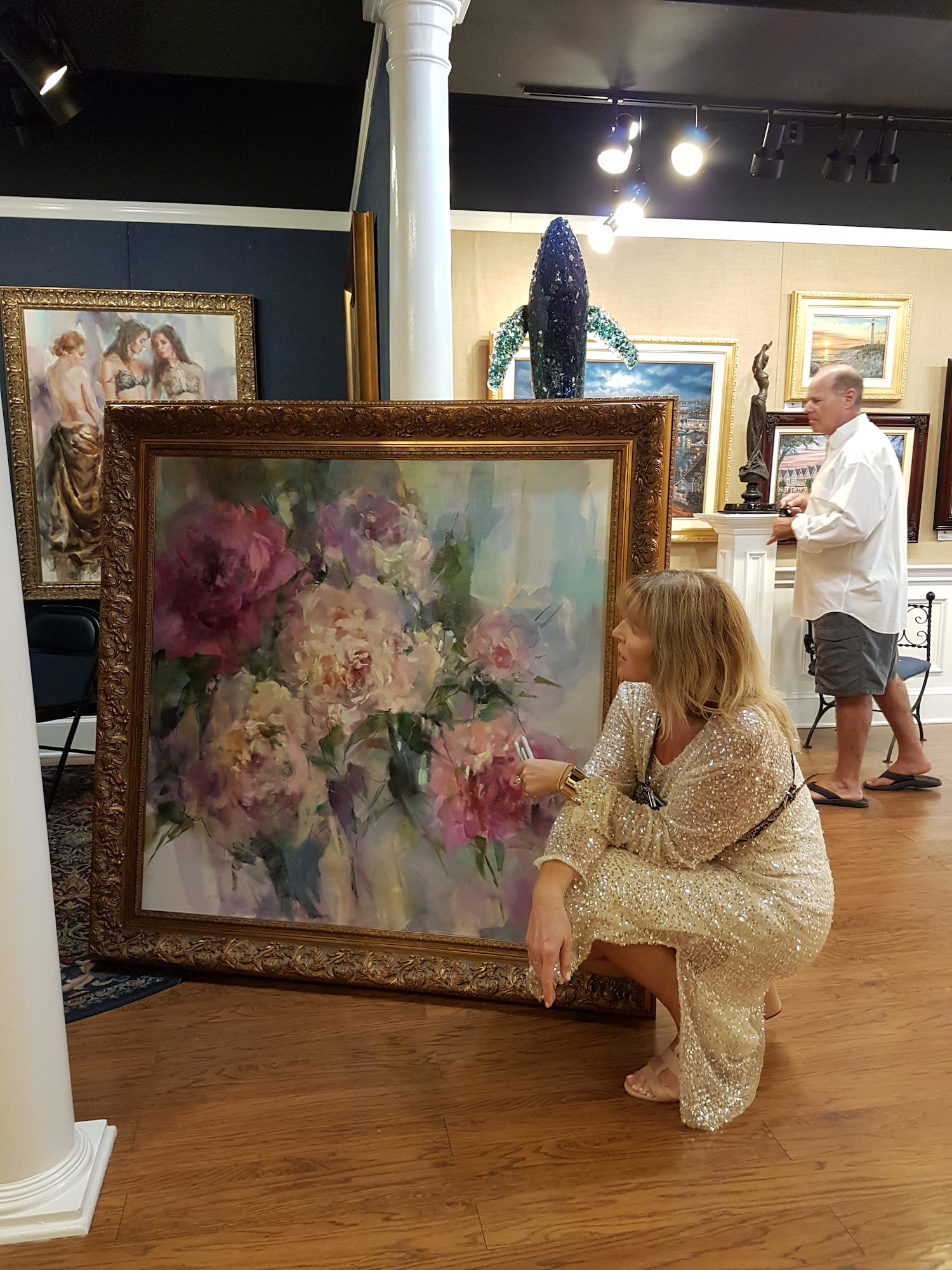 Anna with a large floral canvas in the gallery