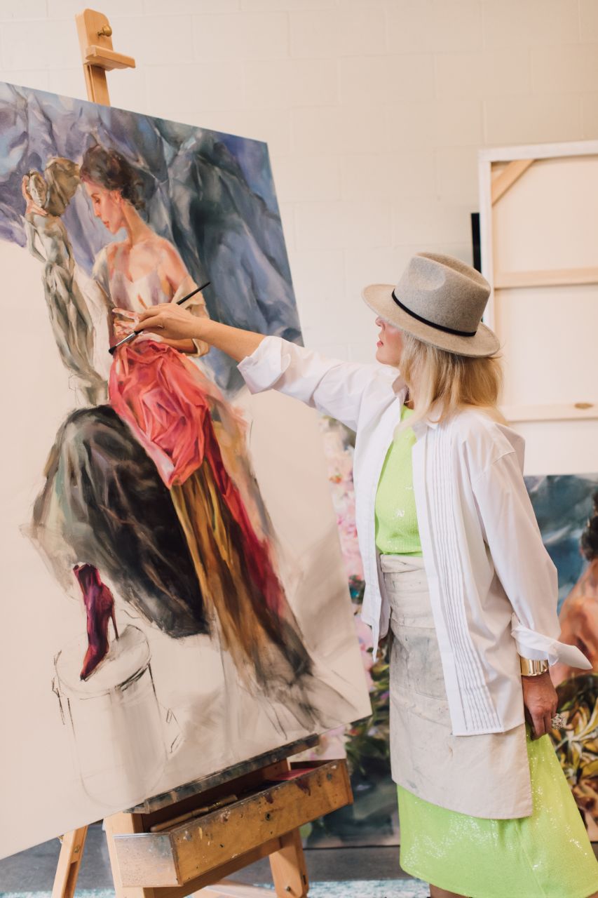 Anna Razumovskaya painting a figure in a red gown at the easel