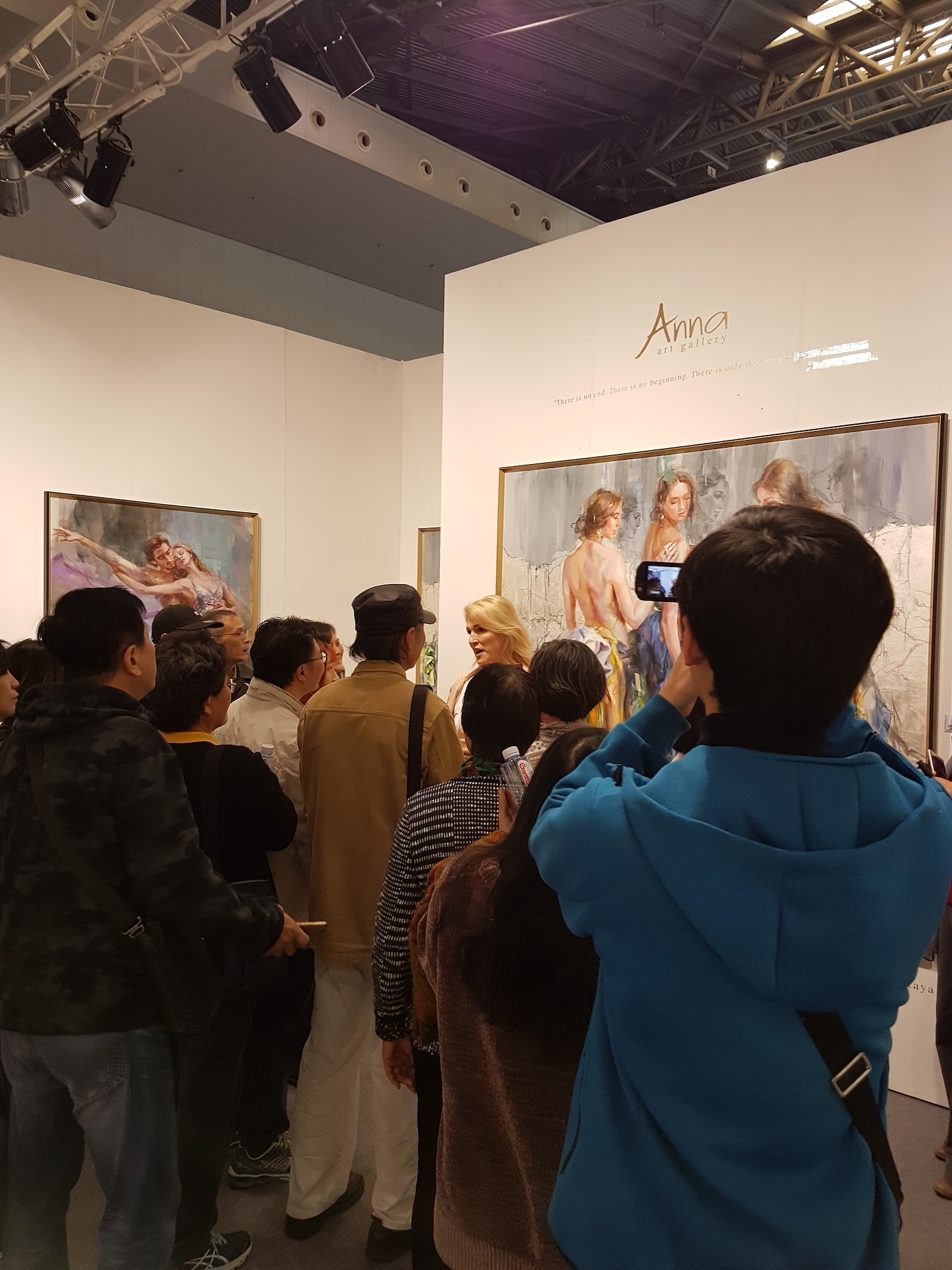 Anna speaking to visitors in front of a large painting